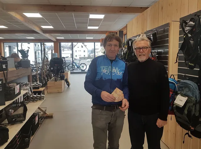 Spendenübergabe zwischen den Regalen im Laden