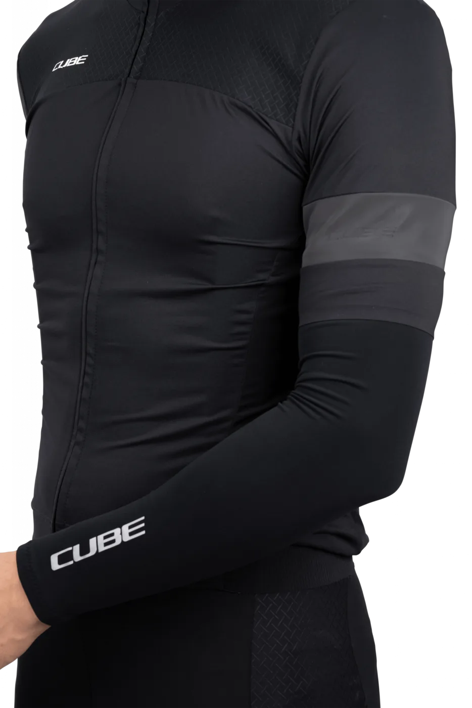 Eine Person trägt CUBE BLACKLINE Armlinge: Schwarze, taillierte Langarm-Radlerhosen mit dem CUBE-Logo auf Brust und Ärmel, verkauft von Mr. Bike Lichtenfels, mit einem reflektierenden grauen Band um den Oberarm.