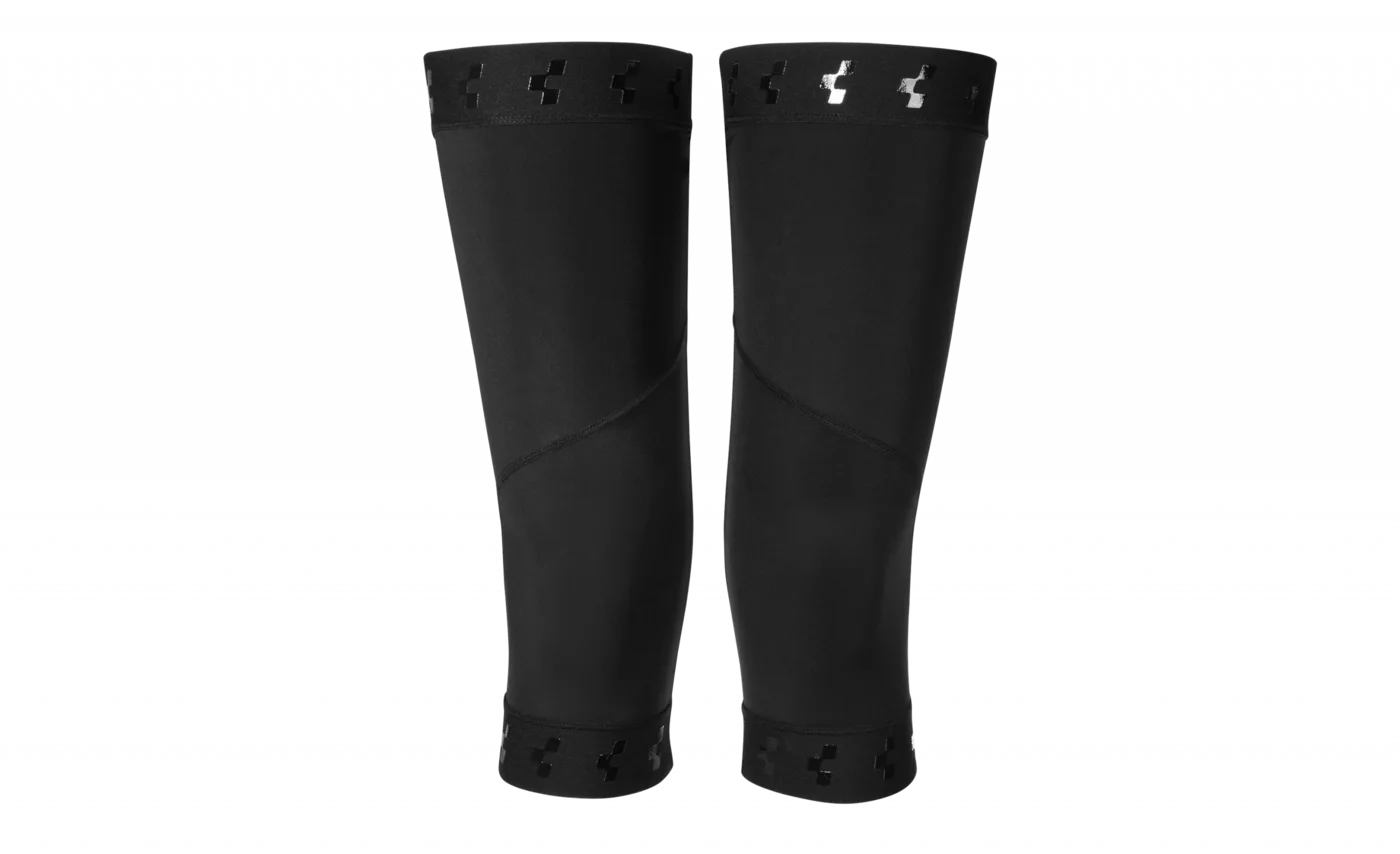 Die CUBE Knielinge RACE cold conditions sind schwarze Knieschutzhüllen mit elastischen Öffnungen, kleinen Aussparungen und einem dezenten, reflektierenden Logo in der Nähe der Oberseite auf weißem Hintergrund.