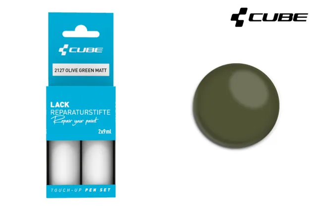 Links ist das CUBE Lackstift Set OLIVE GREEN matt 2127 in blauer Verpackung abgebildet, rechts ein kreisrundes olivgrünes Farbmuster - ideal für Mr. Bike Lichtenfels Fans. In der rechten oberen Ecke ist das CUBE-Logo zu sehen.