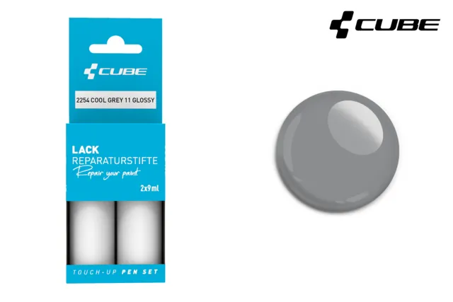 Die Verpackung des CUBE Lackstift Sets COOL GREY 11 glossy 2254 enthält zwei Lackstifte und ein glänzendes graues Muster, das blau beschriftet ist. In der rechten oberen Ecke erscheint das CUBE-Logo, das zu dem von Mr. Bike Lichtenfels passt.