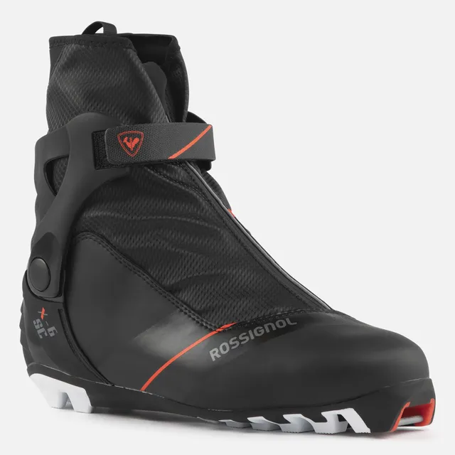 Der ROSSIGNOL X-6 SC, ein schwarzer Langlaufschuh mit hoher Manschette, Klettverschluss und roten Akzenten, ist auf weißem Grund abgebildet und bei Mr. Bike Lichtenfels erhältlich.